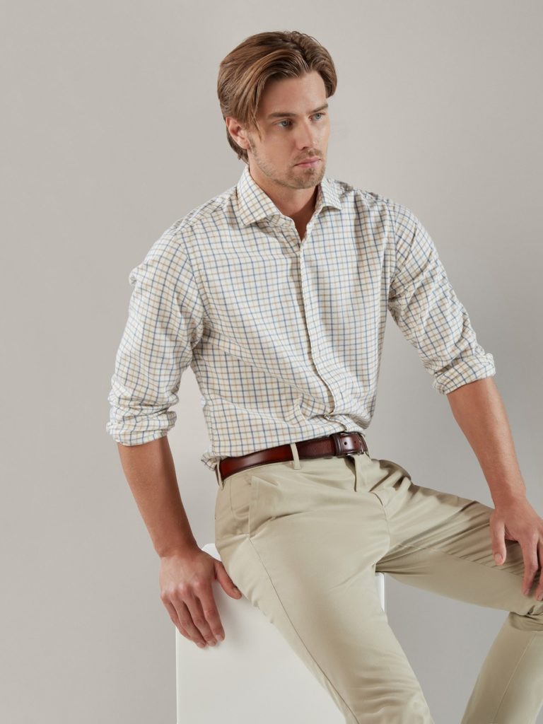 A younger male model with formal dress sitting on a chair