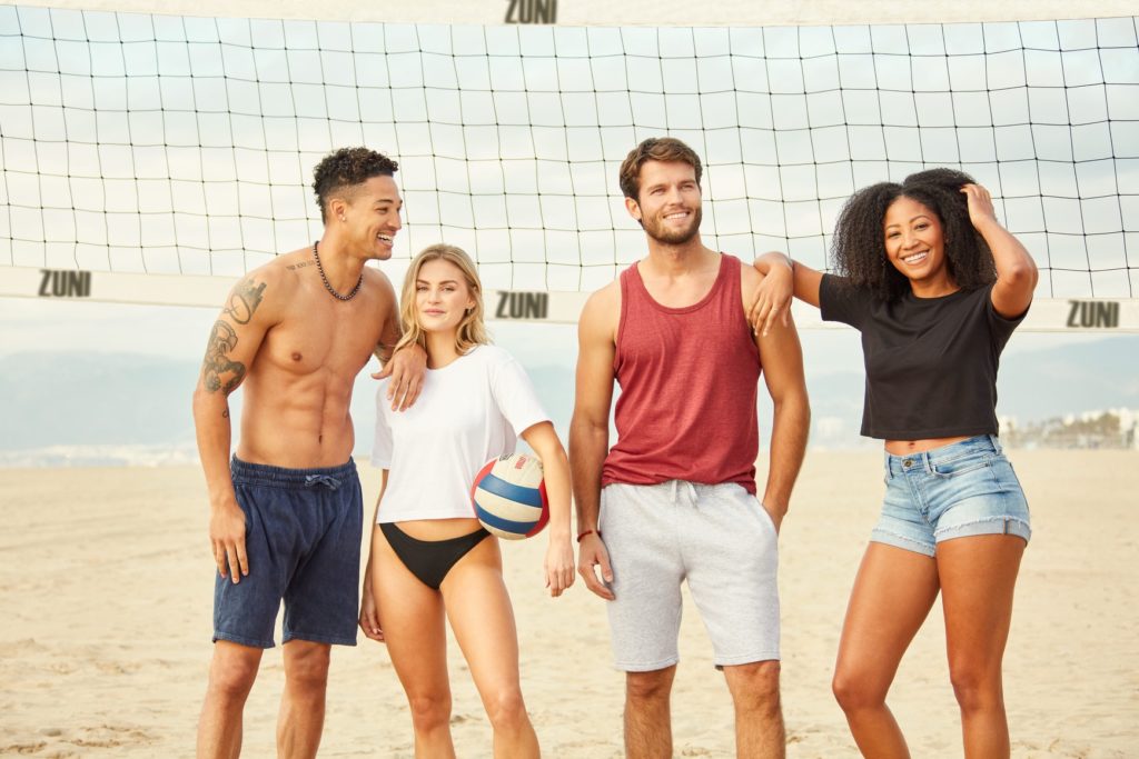 Two romantic couples on beach enjoying beach volley ball game