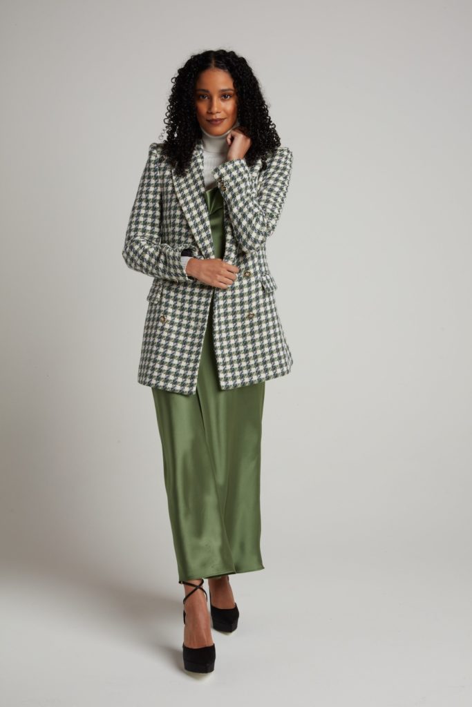 A female model with green long skirt and checked long coat