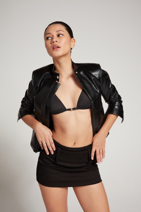 A female model with short black skirt and small black coat