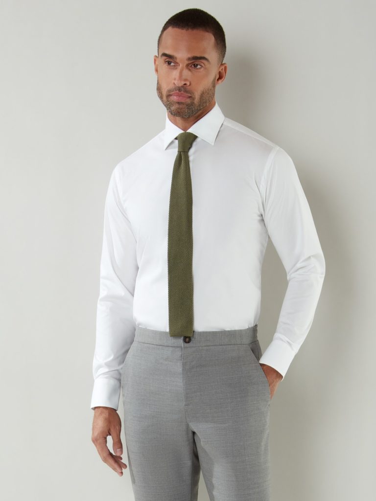 A male model with formal grey pant and white shirt and a green tie