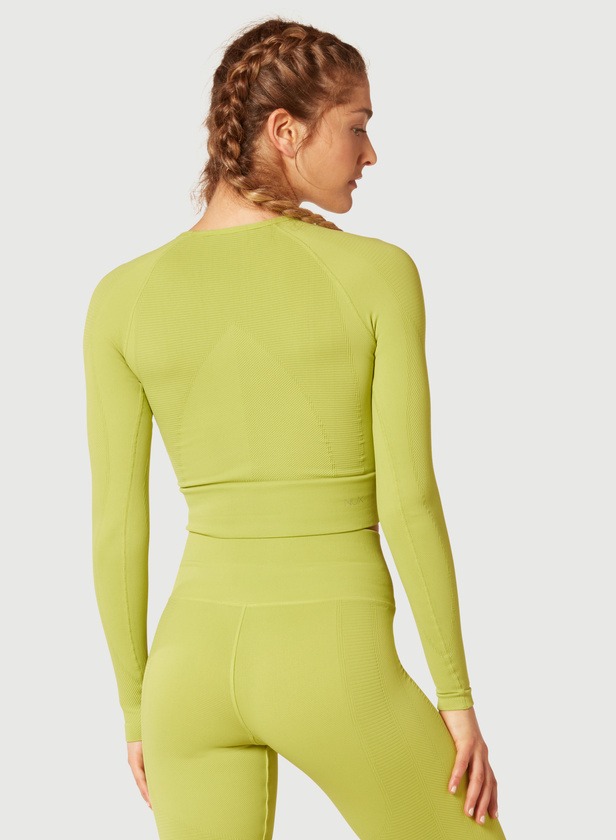 A female model wearing green trousers and green top with full hands back view