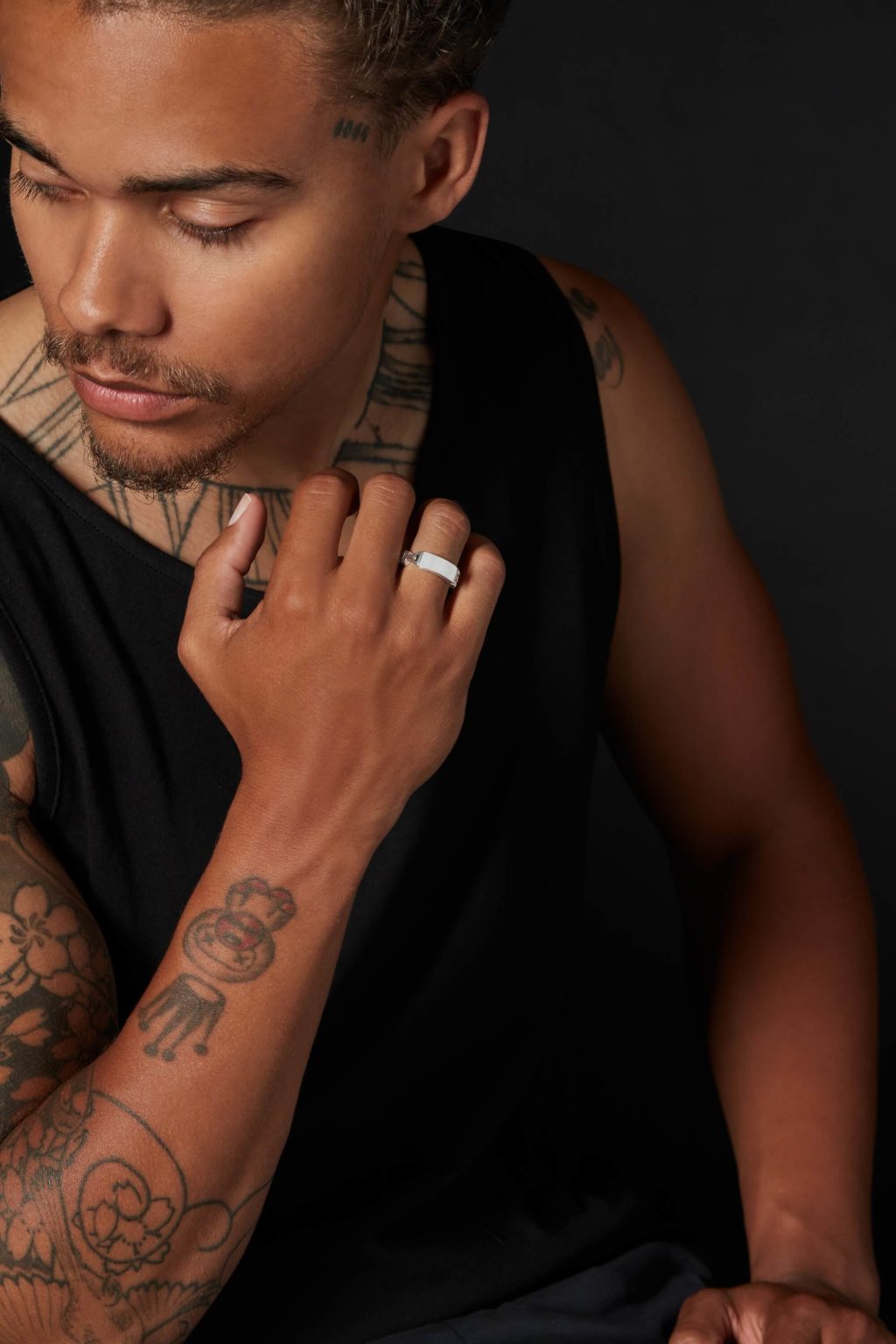 A male model showing tattos on hands and a ring on his finger