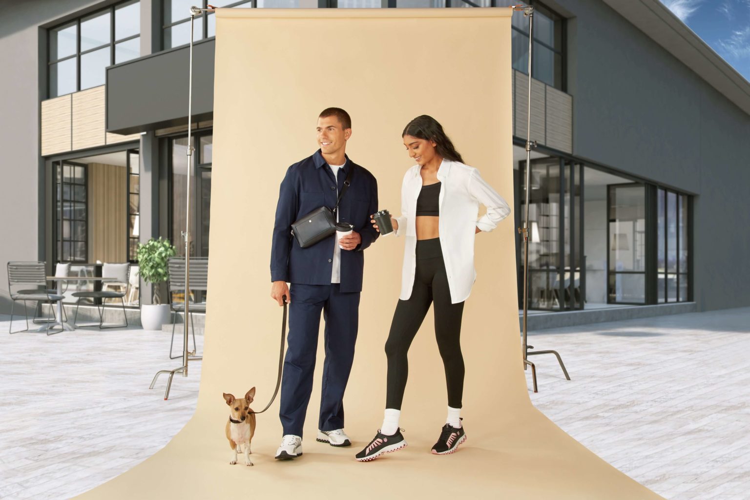 A male and female models in a leisure attire along with a small dog with them in a building background setup for photography