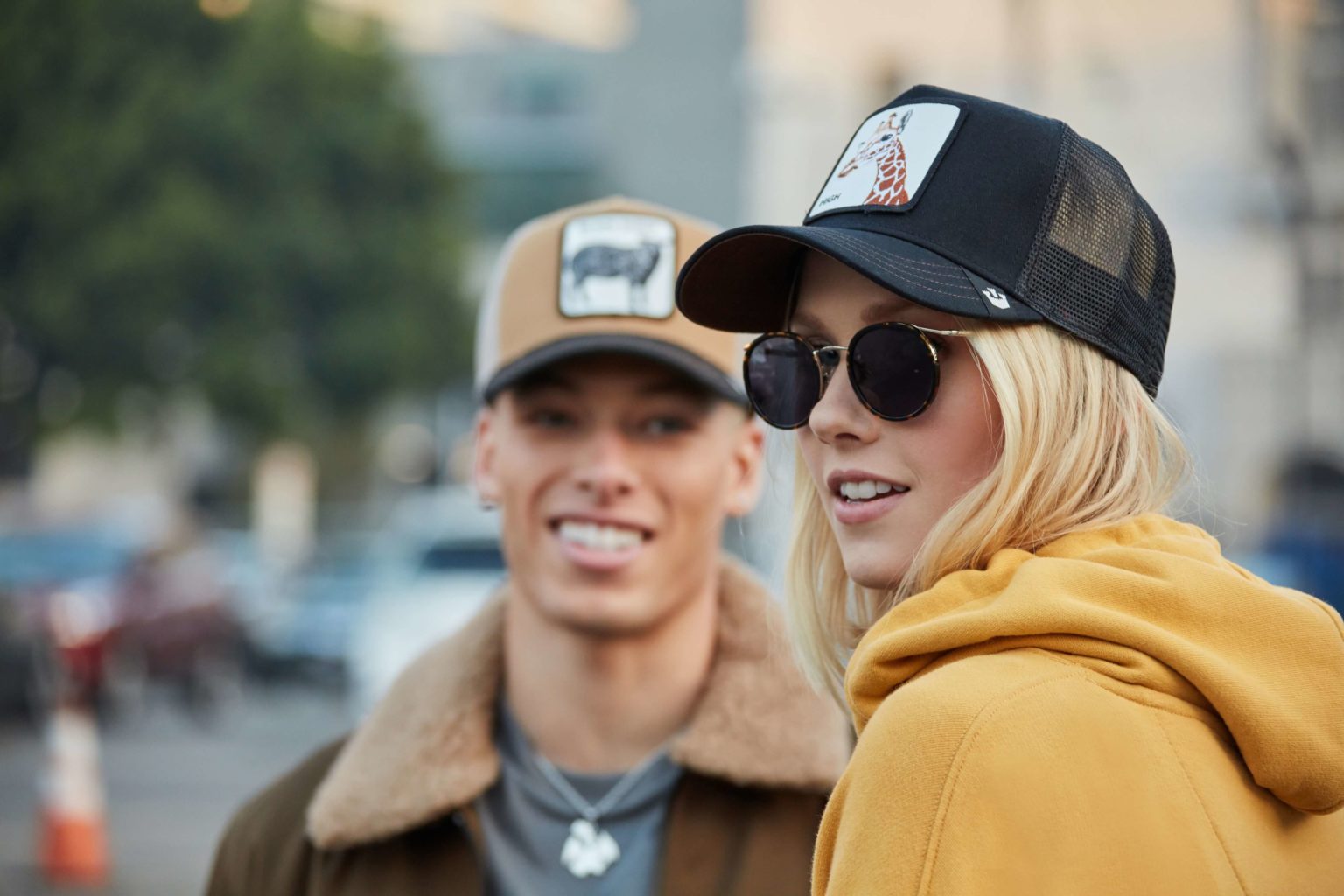 A male and a female models wearing sweaters and caps
