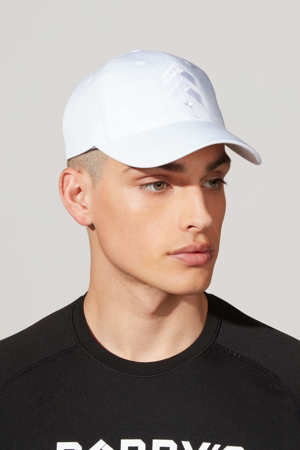 A male model with black tshirt and white cap