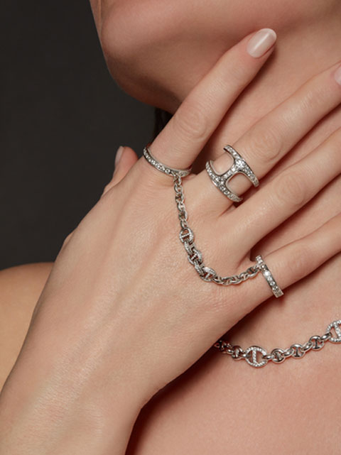 A female model showing her hand and neck jewelry