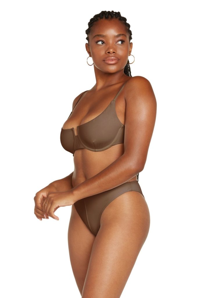 A dark female model with brown bra and panty side view
